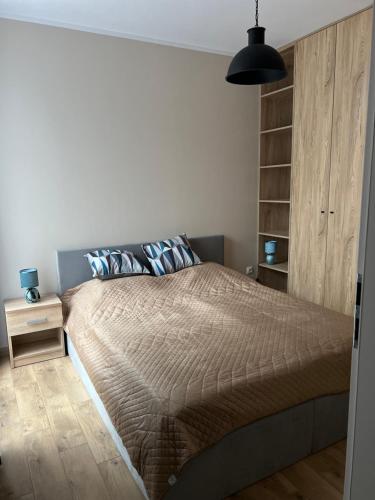ein Schlafzimmer mit einem großen Bett mit einer braunen Decke in der Unterkunft Aquarius Kilińskiego 1 in Grodzisk Mazowiecki
