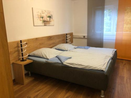 1 dormitorio con 1 cama con cabecero de madera en Gästehaus Jagsttal, en Möckmühl