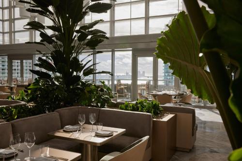 a restaurant with tables and chairs and plants at Hotel AKA Brickell in Miami