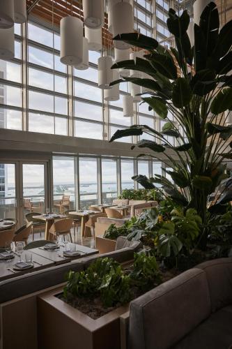 a restaurant with tables and a plant in the middle at Hotel AKA Brickell in Miami