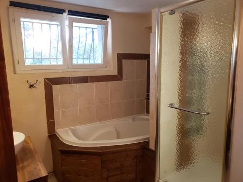 un bagno con vasca e finestra di Orteils au soleil jardin parking a Nîmes