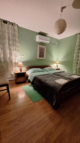 a bedroom with a large bed and a green wall at Dalma in Osijek