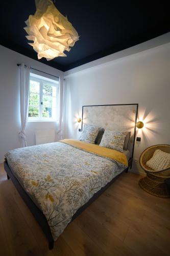une chambre avec un lit, une fenêtre et un lustre dans l'établissement Monseigneur Dijon central & design avec parking, à Dijon