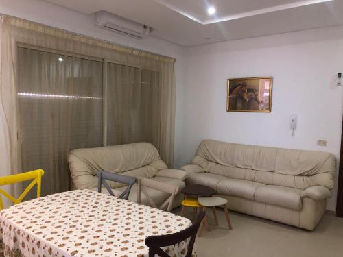 a living room with a couch and a table at Résidence le corail de chat meriem in Sousse
