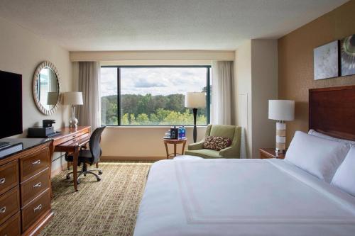 a hotel room with a bed and a desk and a window at Atlanta Marriott Alpharetta in Alpharetta