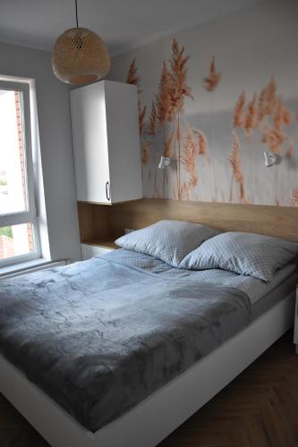 a bedroom with a large bed with a wooden headboard at Apartament pod zegarem in Giżycko