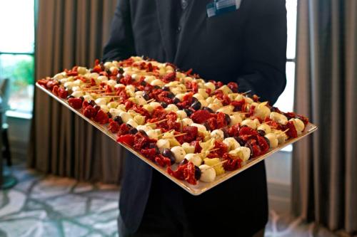 a man is holding a tray of food with berries at Atlanta Marriott Alpharetta in Alpharetta