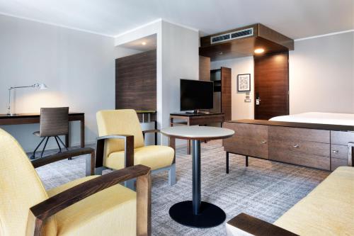 a hotel room with a bed and a tv at Four Points Sheraton Bolzano Bozen in Bolzano