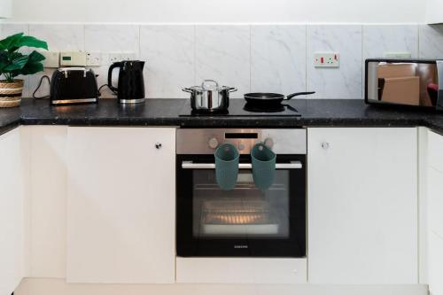 a kitchen with an oven with a pot on it at Cosy decorated flat in Tonbridge in Tonbridge