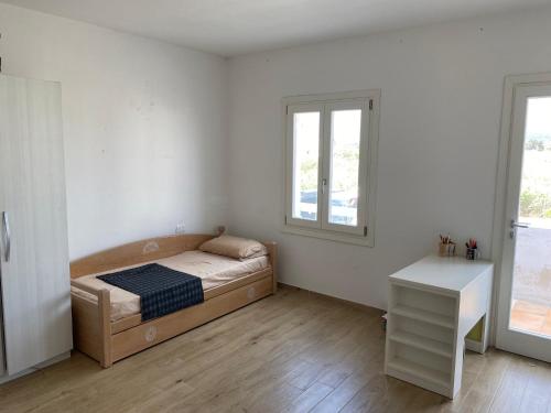 um quarto com uma cama, uma secretária e 2 janelas em Li Lucianeddi em Buoncammino