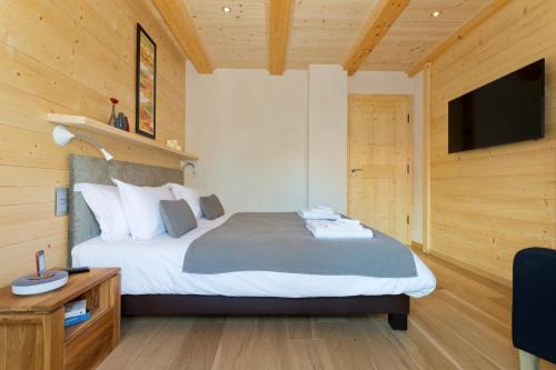 a bedroom with a bed and a television in a room at Chalet Isabelle Mountain lodge 5 star 5 bedroom en suite sauna jacuzzi in Chamonix-Mont-Blanc