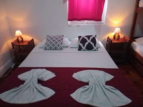 a bedroom with a bed with white sheets and pillows at Pousada Bamboo da Barra in Salvador