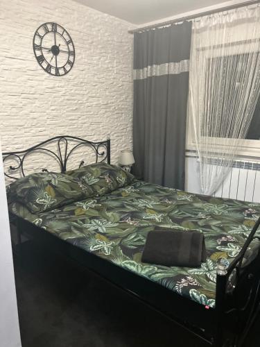 a bedroom with a bed with a clock on the wall at Zajazd Kasieńka in Orzysz