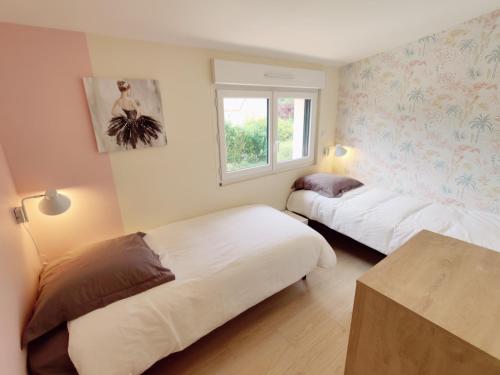 1 dormitorio con 2 camas y ventana en Maison 50m2 - 2 chambres - Jardin en Fontaine-Étoupefour