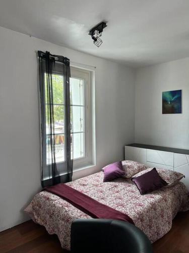 L’Escale: Appartement complet في تور: غرفة نوم مع سرير مع وسائد أرجوانية ونافذة