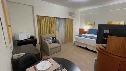 um quarto de hotel com um quarto com uma cama e uma cadeira em Flat c/ Garagem na Rua Borges Lagoa 1179 UH518 em São Paulo