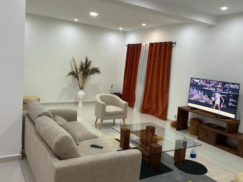 sala de estar con sofá y TV de pantalla plana en Villa d'exception à 20 min de l'aéroport 