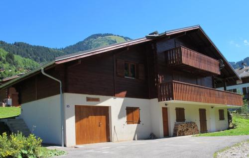 a house with wooden doors and a balcony at Les Sapins - Welcoming chalet for 14p with hot tub in Châtel