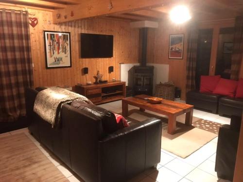 a living room with a couch and a table at Les Sapins - Welcoming chalet for 14p with hot tub in Châtel