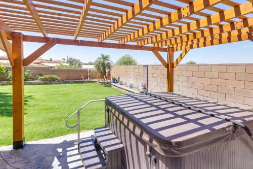 a patio with a wooden pergola and a lawn at Lovely Bullhead City Retreat with Patio and Grill! in Bullhead City