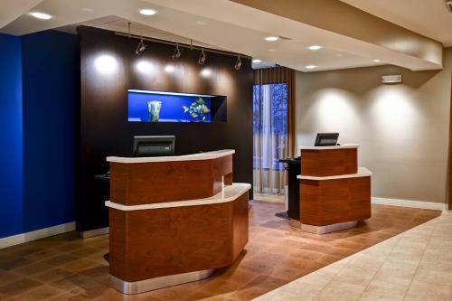 a lobby with a reception desk and a tv on the wall at Courtyard Cape Cod Hyannis in Hyannis