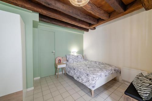sypialnia z łóżkiem i krzesłem w obiekcie Le cosy de Tonnerre w mieście Tonnerre