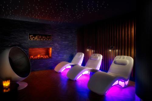 a group of white chairs in a room with a fireplace at Sheraton Grand Hotel & Spa in Edinburgh