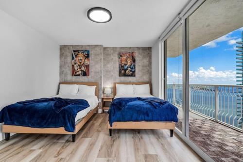 Dreamy Oceanfront Highfloor Corner Unit 2and2 plus Den في ميامي: سريرين في غرفة نوم مع شرفة
