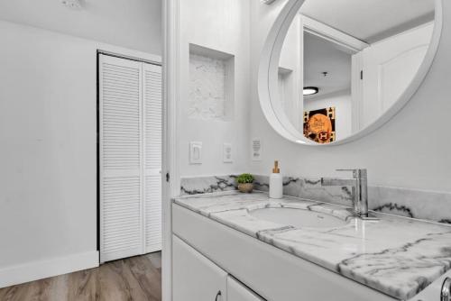 Dreamy Oceanfront Highfloor Corner Unit 2and2 plus Den في ميامي: حمام أبيض مع حوض ومرآة