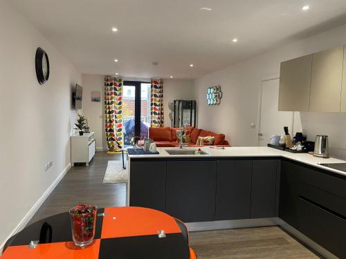 an open kitchen and living room with an orange table at Modern en-suite room and self catering in london in Woolwich