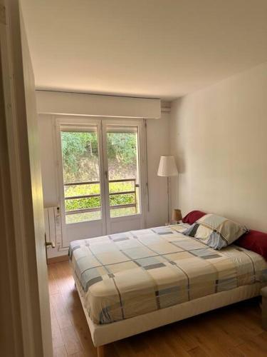 une chambre avec un lit et une grande fenêtre dans l'établissement Appartement 3 pièces, à Le Port-Marly