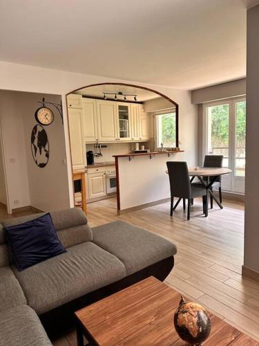 un salon avec un canapé et une table et une cuisine dans l'établissement Appartement 3 pièces, à Le Port-Marly