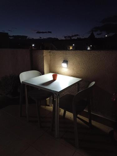 a table and two chairs on a balcony at night at Pagés in Sant Climent Sescebes