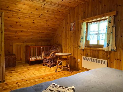 a bedroom with a bed and a table and a window at Domki nad stawami - Pommernhof in Ustronie Morskie