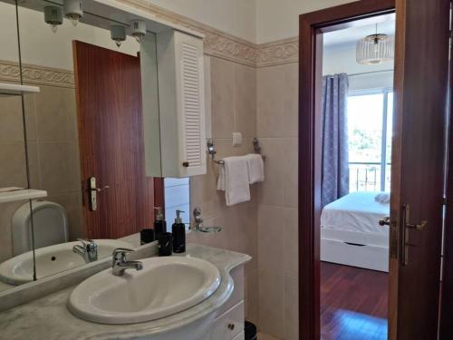 a bathroom with a sink and a tub and a mirror at Villa&Damata in Água de Pena