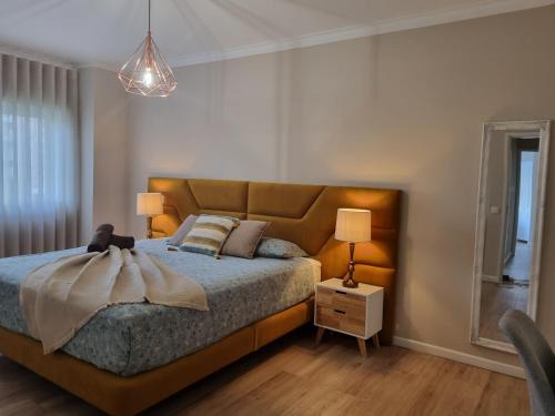 a bedroom with a bed and a lamp and a mirror at Diamante house com garagem privada in Braga