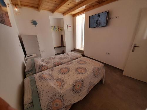 1 dormitorio con 2 camas y TV en la pared en Ibiza Suite Independent bedroom and bathroom, en Albufeira