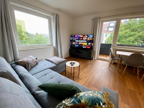 un soggiorno con divano blu e TV a schermo piatto di LEMON - 4 Per - Garage - 65 Zoll a Braunschweig
