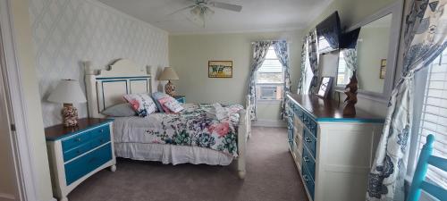 a bedroom with a bed and a blue dresser at Pierhouse Bed & Breakfast in Kill Devil Hills