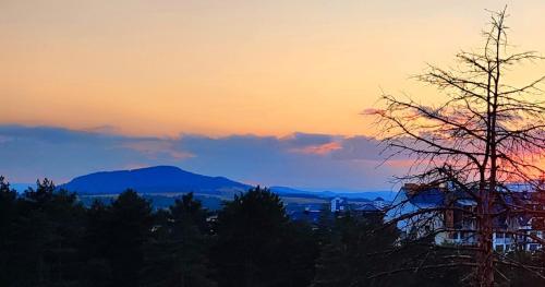a sunset with trees and mountains in the background at BalkanHill2 S37 Pekovic green in Zlatibor