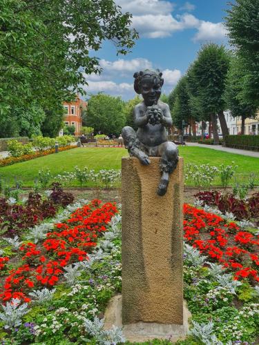 a statue of a little boy sitting on a rock in a garden at Altstadt Domizil in Pirna