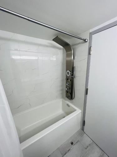 a white bath tub in a bathroom with a white wall at Lively Inn and Suites - Sudbury in Naughton
