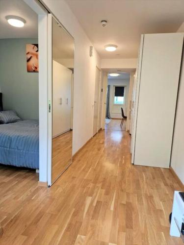 an empty room with a bed and a mirror at Demims Apartments Lorenskog centre -- Ahus & SNØ & Parking in Lorenskog
