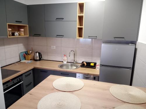 a kitchen with a wooden table with two plates on it at Sara Lux in Lukavica