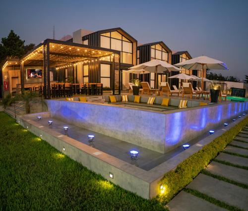 una casa con piscina di notte di Awqa Loft & Camp a Trujillo
