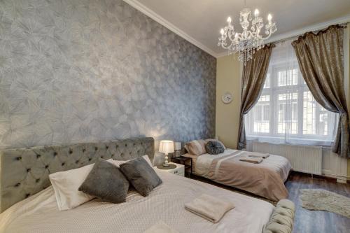 a bedroom with two beds and a chandelier at Buda Center Apartment in Budapest