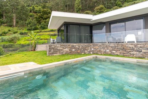 a swimming pool in front of a house at Villa Rocha in Arco da Calheta in Arco da Calheta