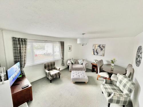 a living room filled with furniture and a flat screen tv at Cae Glas Apartments in Holyhead