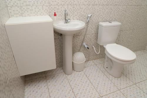 a bathroom with a white toilet and a sink at Canoa Quebrada House in Canoa Quebrada