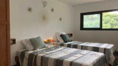 a bedroom with two beds and a window at O Verger in Saint-André